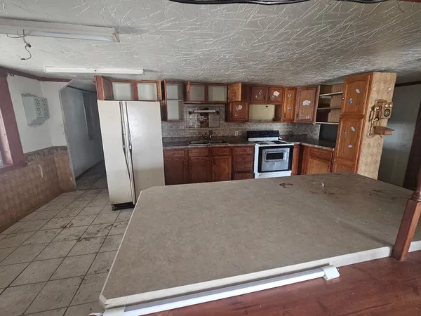 a kitchen with stainless steel appliances granite countertop a refrigerator a stove and a sink