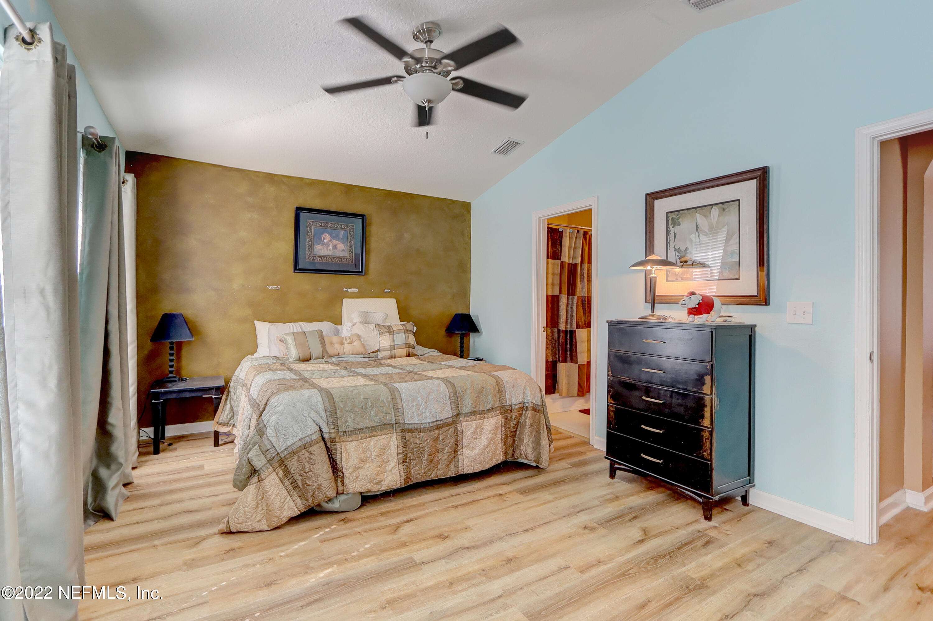12952 Spring Rain Road Jacksonville, FL 32258 - Photo 23 of 28 a bedroom with a bed and a chandelier