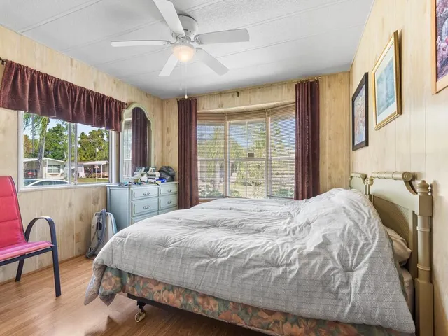 a bed sitting in a spacious bedroom next to a window