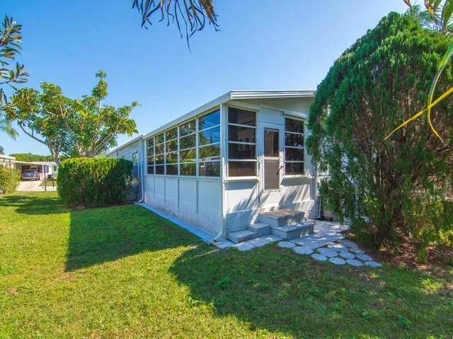 a view of a backyard with table and chairs and potted plants with wooden fence