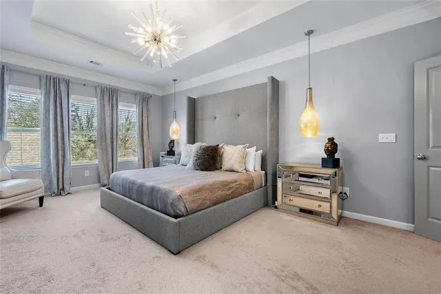 a spacious bedroom with a bed and a chandelier