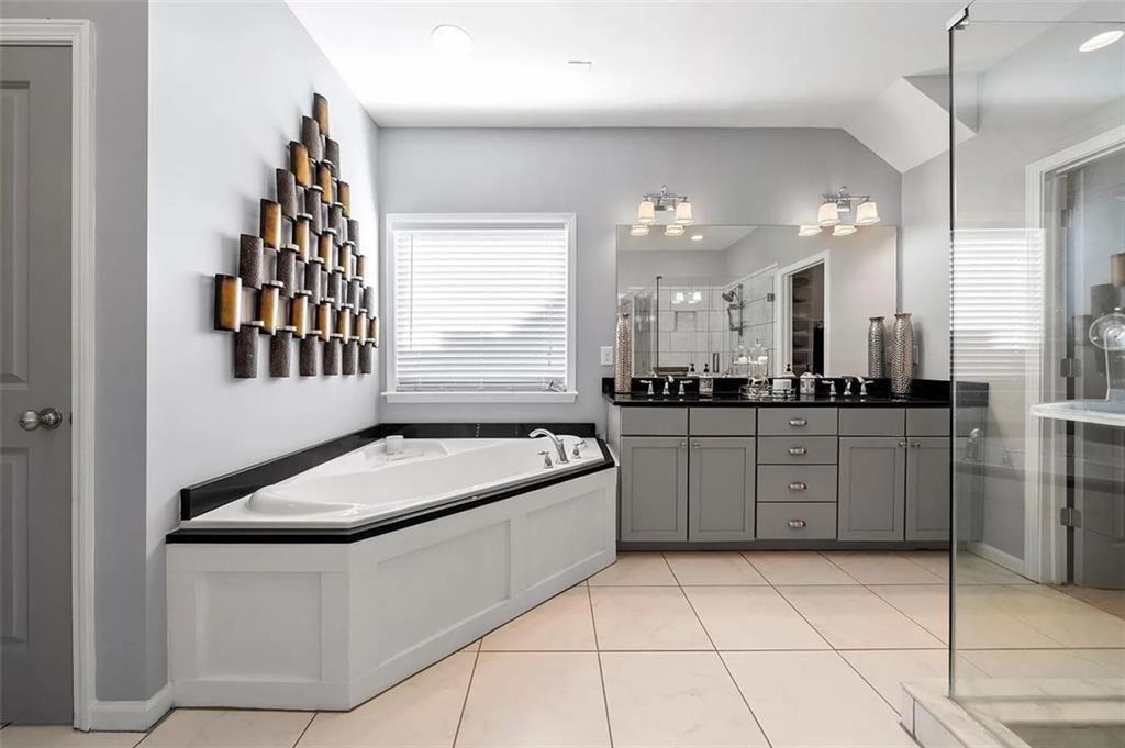 3165 Oakdale Road Atlanta, GA 30354 - Photo 22 of 35 a bathroom with a granite countertop sink a mirror and a bathtub