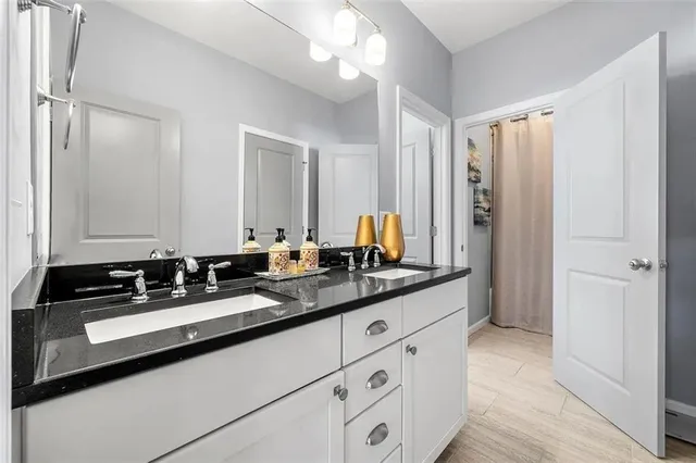 a bathroom with double sink and a mirror