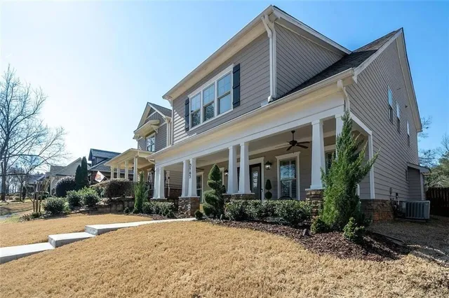 a front view of a house with a yard and potted plants