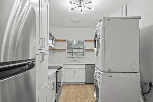 a kitchen with a sink a refrigerator a washer and dryer