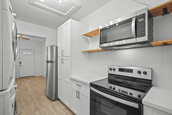 a kitchen with stainless steel appliances a stove and a microwave