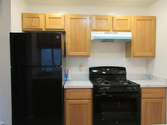 a kitchen with a refrigerator and a stove