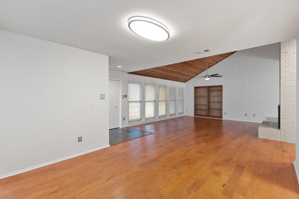 1036 Clinton Street Carrollton, TX 75007 - Photo 11 of 40 Unfurnished living room with light wood finished floors, a fireplace, lofted ceiling, a ceiling fan, and wood ceiling