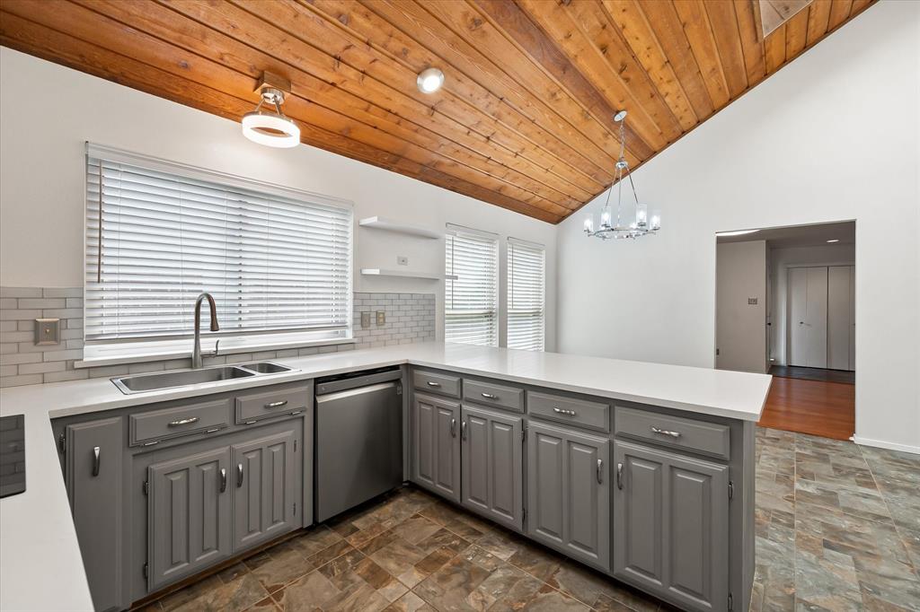 1036 Clinton Street Carrollton, TX 75007 - Photo 16 of 40 Kitchen featuring gray cabinetry, a peninsula, stainless steel dishwasher, hanging light fixtures, and wooden ceiling