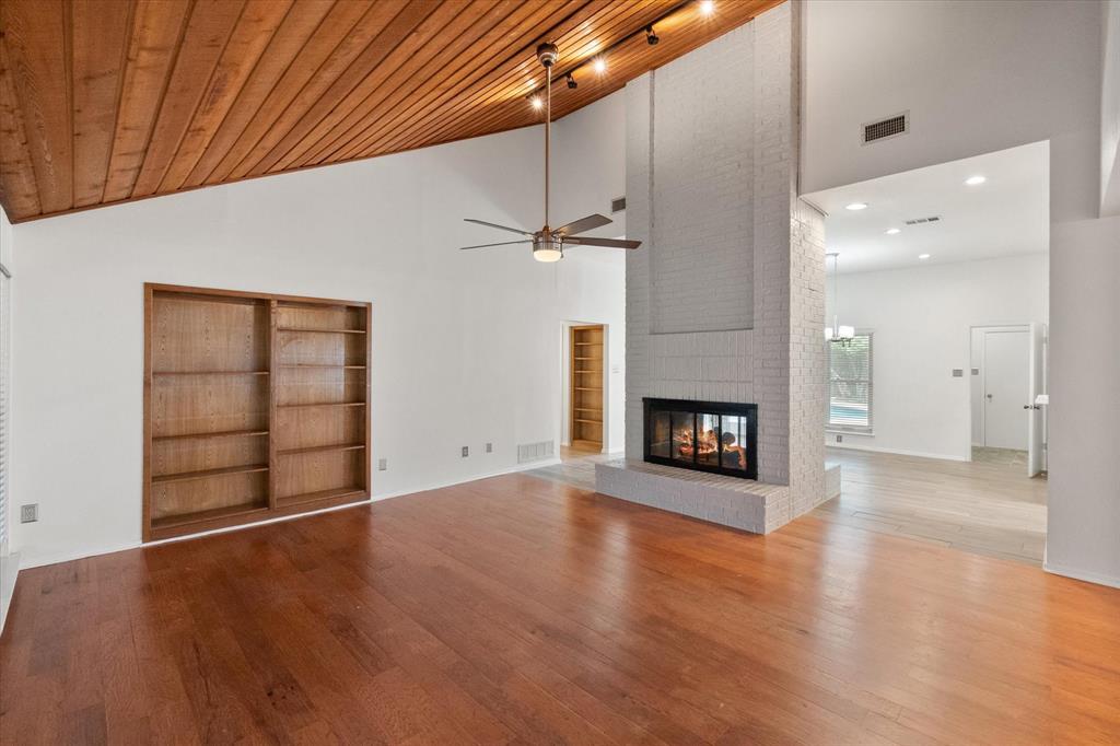 1036 Clinton Street Carrollton, TX 75007 - Photo 4 of 40 Unfurnished living room featuring hardwood / wood-style floors, high vaulted ceiling, a fireplace, a ceiling fan, and wood ceiling