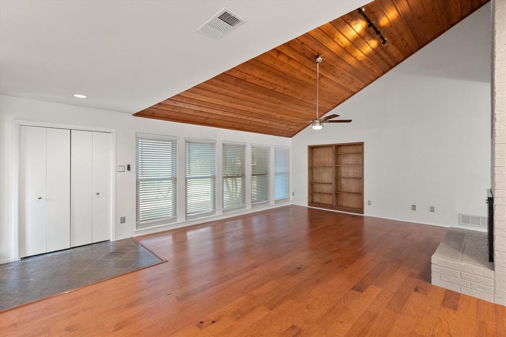 1036 Clinton Street Carrollton, TX 75007 - Photo 8 of 40 Unfurnished living room with light wood-type flooring, wooden ceiling, a fireplace, high vaulted ceiling, and ceiling fan