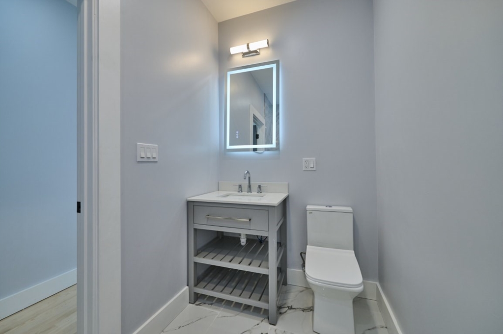 97 Oakton Avenue, Unit 1 Boston, MA 02122 - Photo 16 of 20 a white toilet sitting next to a bathroom sink