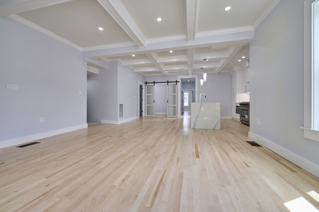 97 Oakton Avenue, Unit 1 Boston, MA 02122 - Photo 4 of 20 an empty room with wooden floor and windows