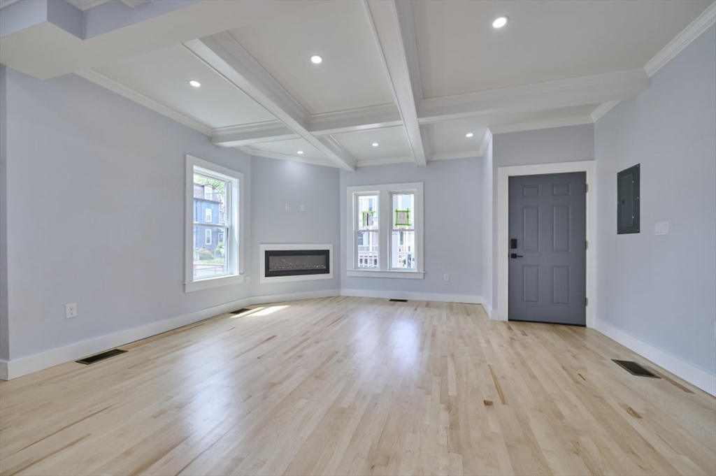 97 Oakton Avenue, Unit 1 Boston, MA 02122 - Photo 5 of 20 a view of an empty room with wooden floor and a window