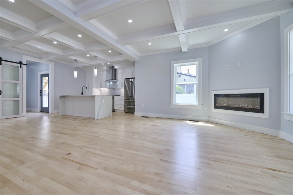 97 Oakton Avenue, Unit 1 Boston, MA 02122 - Photo 6 of 20 a view of an empty room with a kitchen and a window
