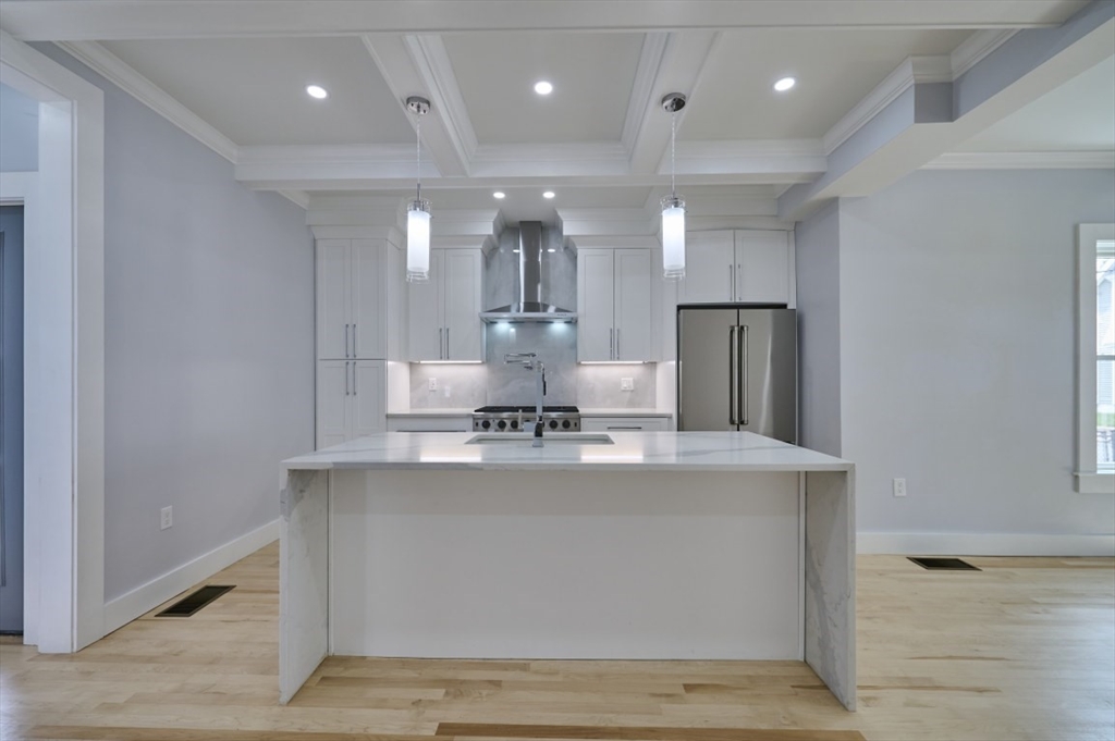 97 Oakton Avenue, Unit 1 Boston, MA 02122 - Photo 7 of 20 a view of a kitchen with kitchen island a sink wooden floor and stainless steel appliances