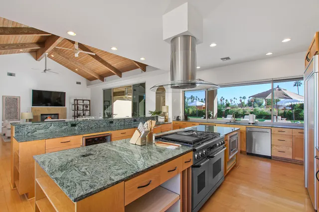a large kitchen with stainless steel appliances granite countertop a stove and a sink