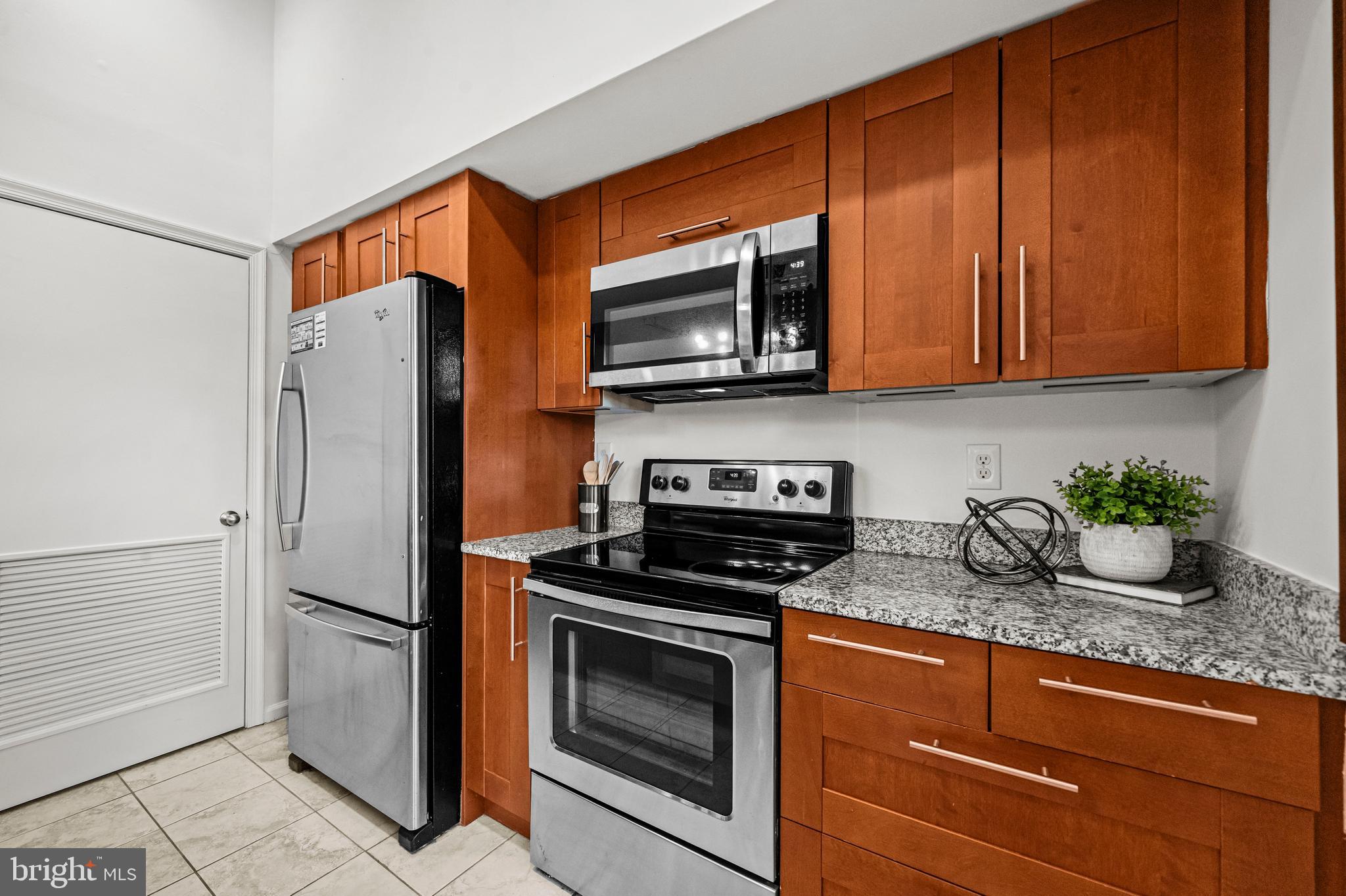 4531 28th Road South, Unit 97 Arlington, VA 22206 - Photo 11 of 32 a kitchen with granite countertop stainless steel appliances a stove a microwave a refrigerator and cabinets