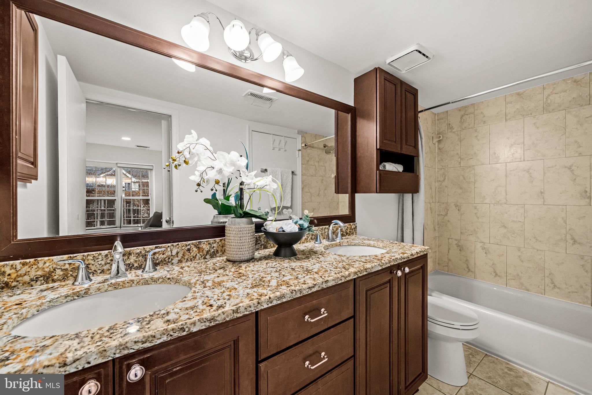 4531 28th Road South, Unit 97 Arlington, VA 22206 - Photo 19 of 32 a bathroom with a granite countertop sink a toilet a large mirror and shower