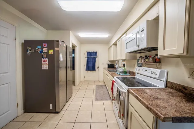 a kitchen with stainless steel appliances granite countertop a refrigerator and a stove
