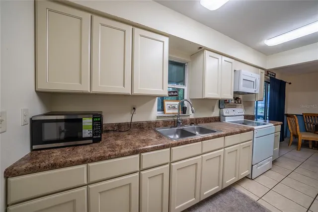 a kitchen with granite countertop white cabinets sink and stainless steel appliances