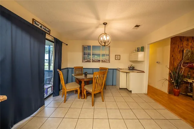 a view of a dining room with furniture and a chandelier