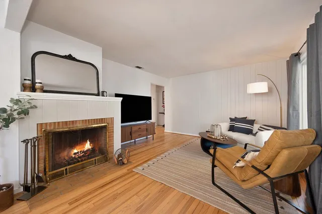 a living room with furniture a fireplace and a flat screen tv