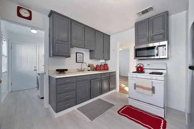 a kitchen with stainless steel appliances a stove cabinets and a kitchen island