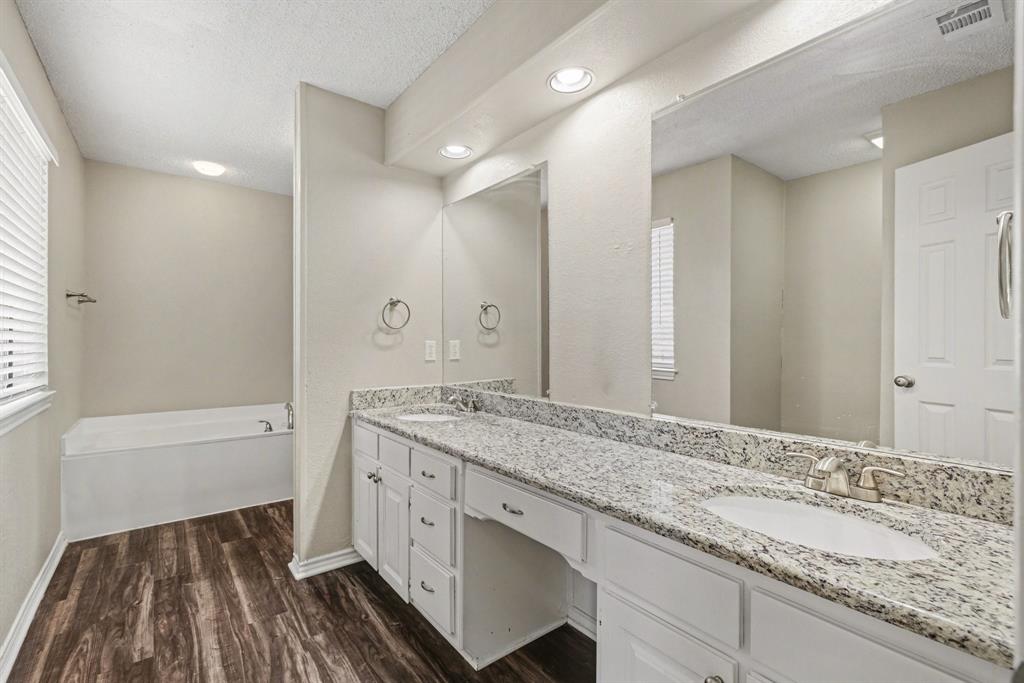 124 Summit Cove Trophy Club, TX 76262 - Photo 13 of 23 a bathroom with a granite countertop sink a mirror and a bathtub