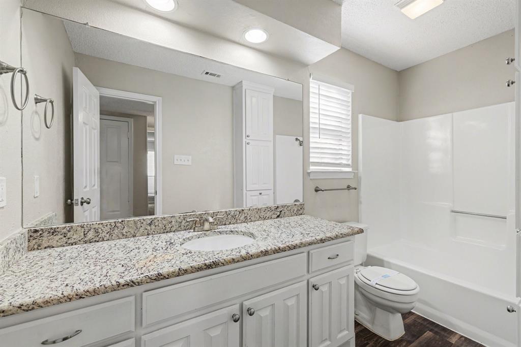 124 Summit Cove Trophy Club, TX 76262 - Photo 16 of 23 a bathroom with a granite countertop sink toilet and mirror