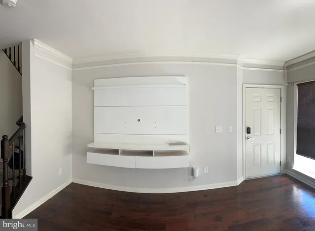 a view of an empty room with wooden floor and closet