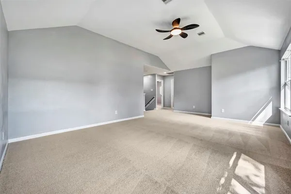 a view of an empty room with a ceiling fan