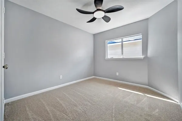 a view of room with a ceiling fan and window