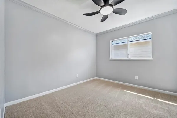 an empty room with a window and a fan