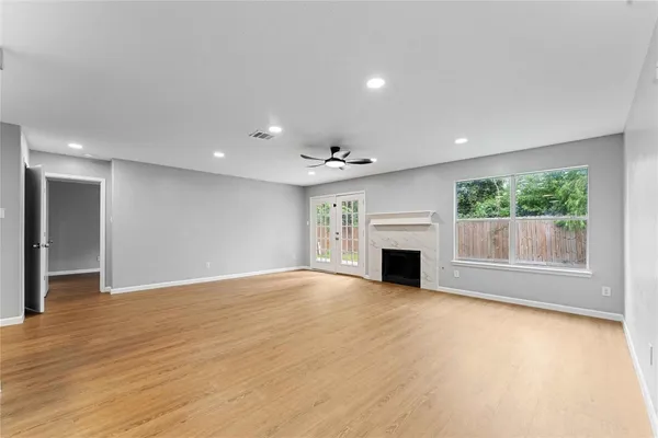 an empty room with windows and fireplace