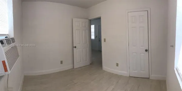a view of a kitchen with white cabinets and wooden floor
