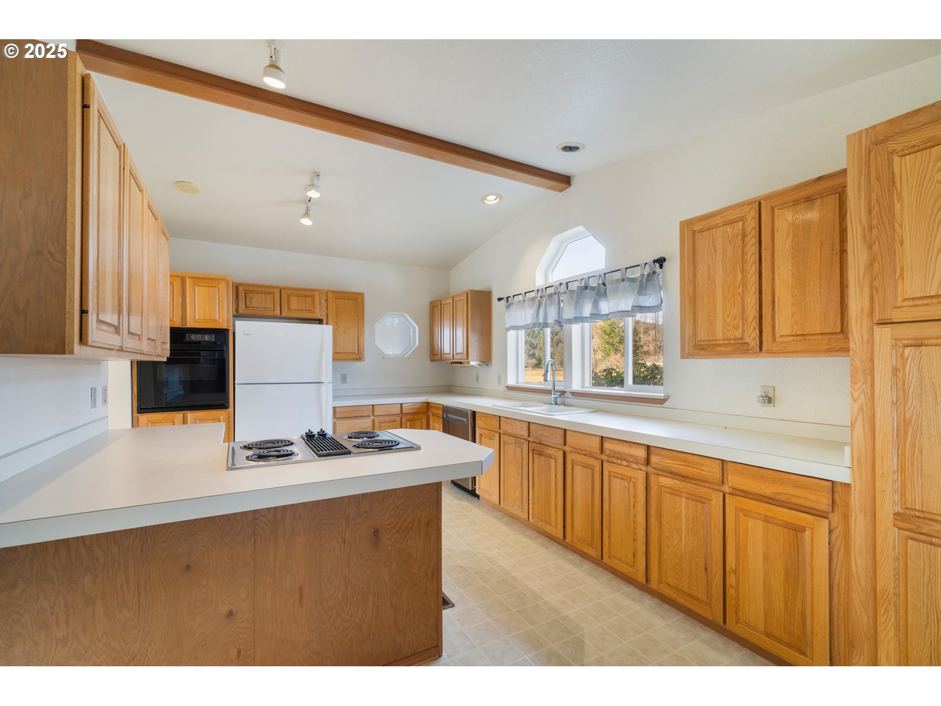 9776 South Prairie Road Tillamook, OR 97141 - Photo 14 of 38 a kitchen with kitchen island granite countertop a sink cabinets and window