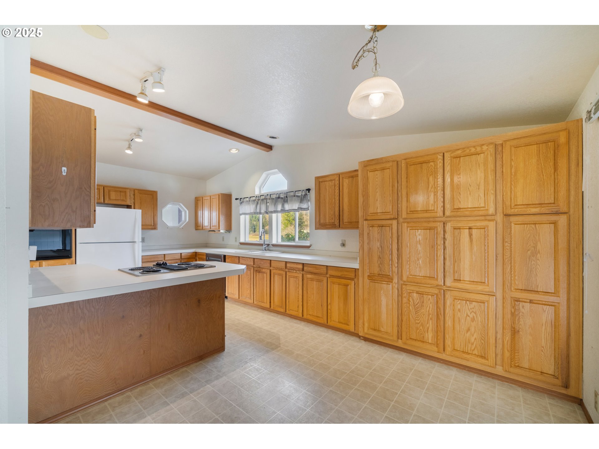 9776 South Prairie Road Tillamook, OR 97141 - Photo 17 of 38 a kitchen with stainless steel appliances granite countertop a refrigerator a sink dishwasher and white cabinets with wooden floor