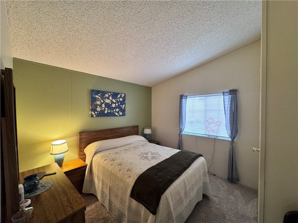 2532 Morgan Road Fort Mohave, AZ 86426 - Photo 9 of 29 Carpeted bedroom featuring a textured ceiling and vaulted ceiling
