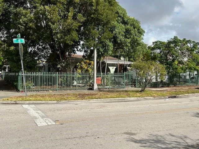 a view of a house with a big yard and large trees