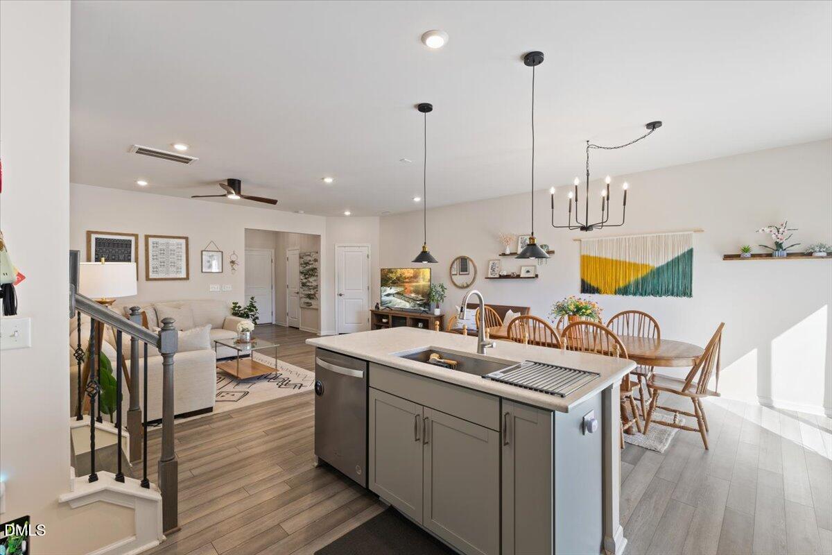 704 Colby Place Durham, NC 27713 - Photo 14 of 34 a room with stainless steel appliances kitchen island granite countertop a table chairs and a wooden floor
