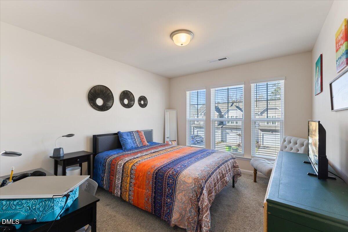 704 Colby Place Durham, NC 27713 - Photo 18 of 34 a bedroom with a bed and wooden floor