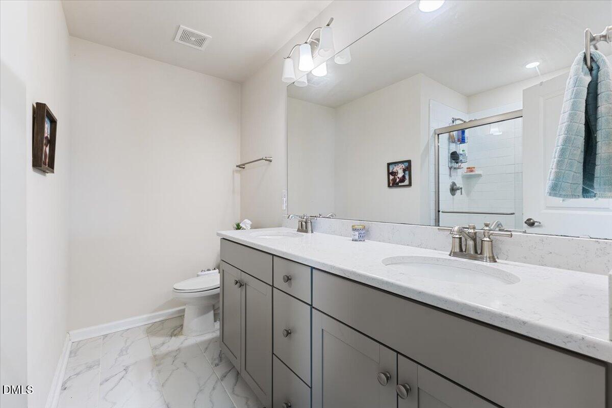 704 Colby Place Durham, NC 27713 - Photo 26 of 34 a bathroom with a granite countertop sink mirror vanity and toilet