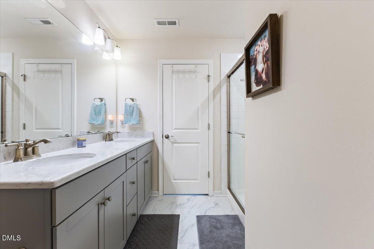 704 Colby Place Durham, NC 27713 - Photo 28 of 34 a bathroom with a double vanity sink and mirror