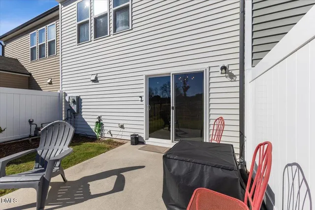 a view of backyard with seating space and wooden fence