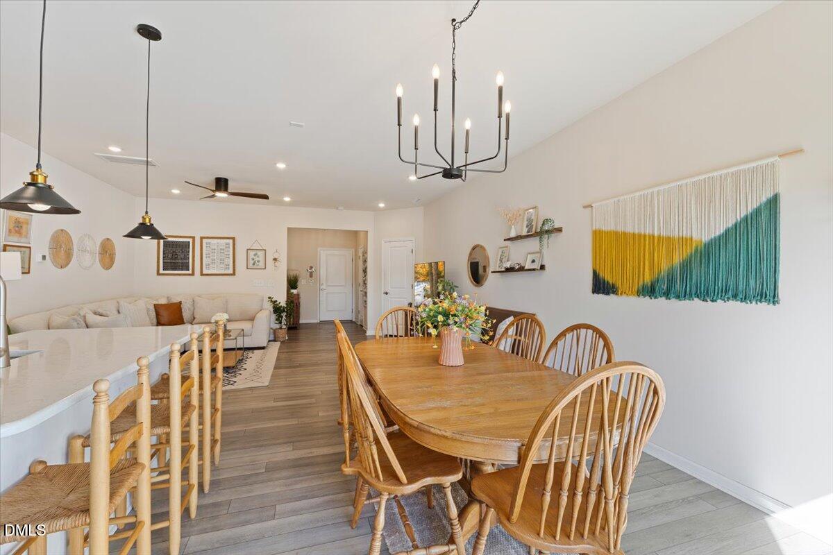 704 Colby Place Durham, NC 27713 - Photo 9 of 34 a view of a dining room and livingroom with furniture wooden floor a chandelier