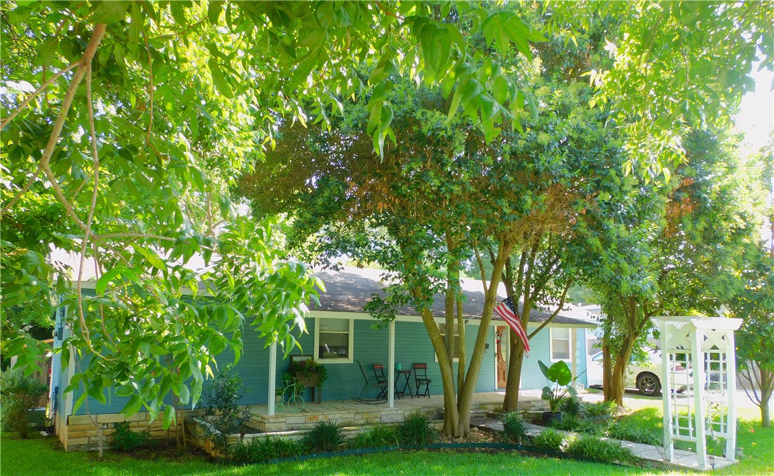 a view of a house with a tree in front of it