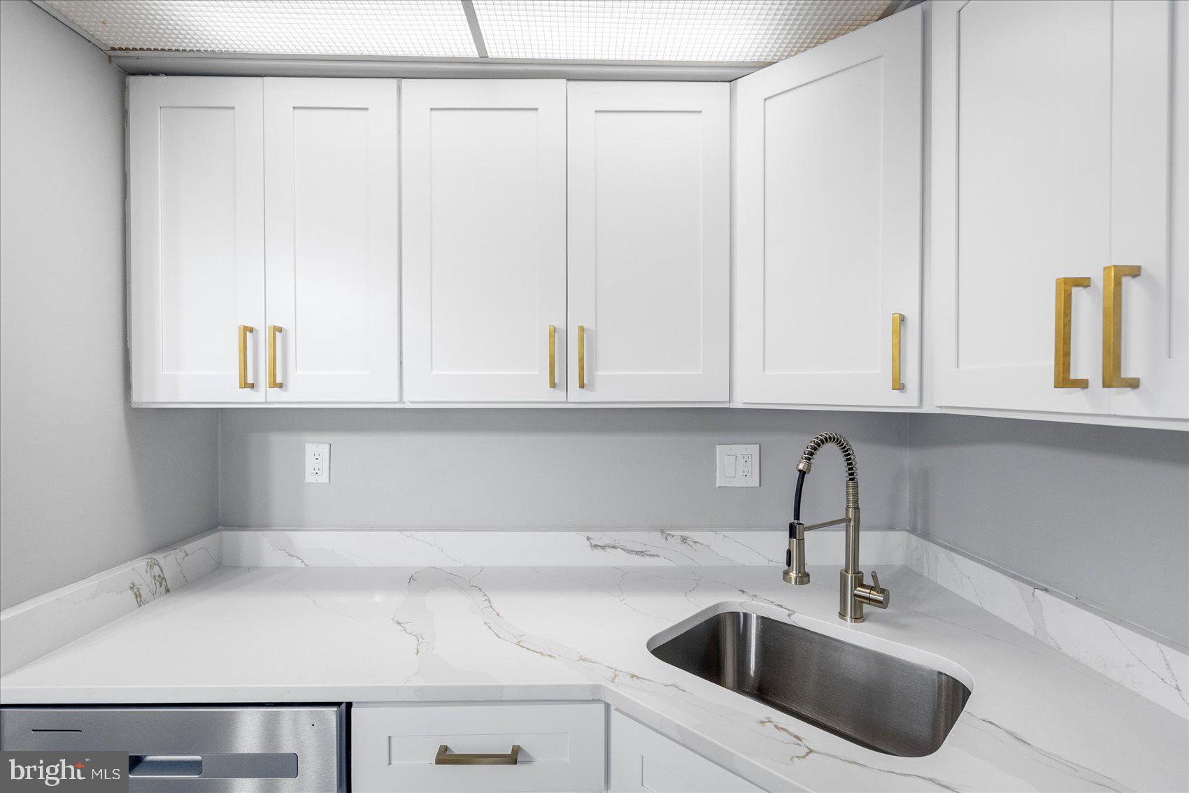 6317 Park Heights Avenue, Unit 616 Baltimore, MD 21215 - Photo 14 of 36 a kitchen with white cabinets and a sink