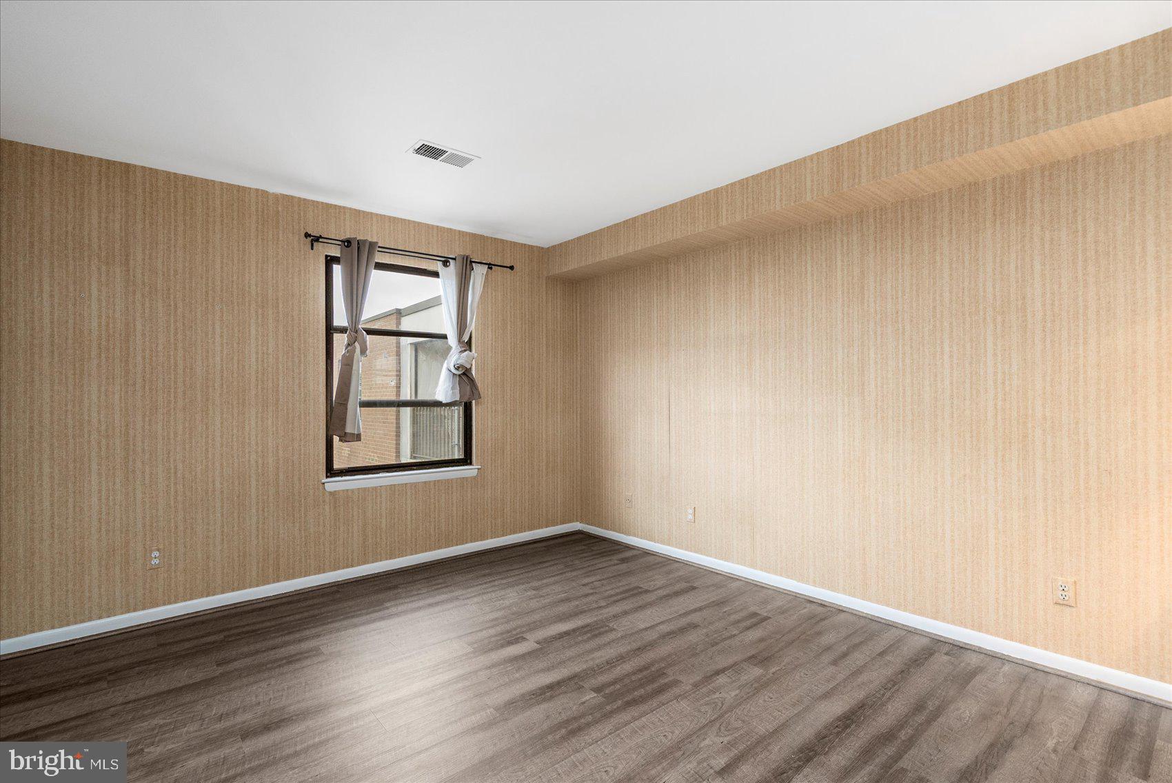 6317 Park Heights Avenue, Unit 616 Baltimore, MD 21215 - Photo 19 of 36 wooden floor in an empty room with a window