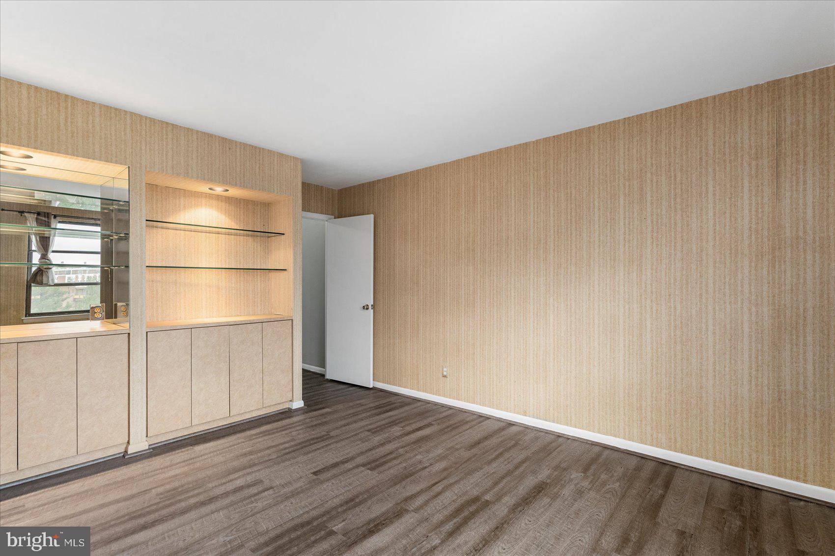 6317 Park Heights Avenue, Unit 616 Baltimore, MD 21215 - Photo 20 of 36 a view of an empty room with a window and wooden floor